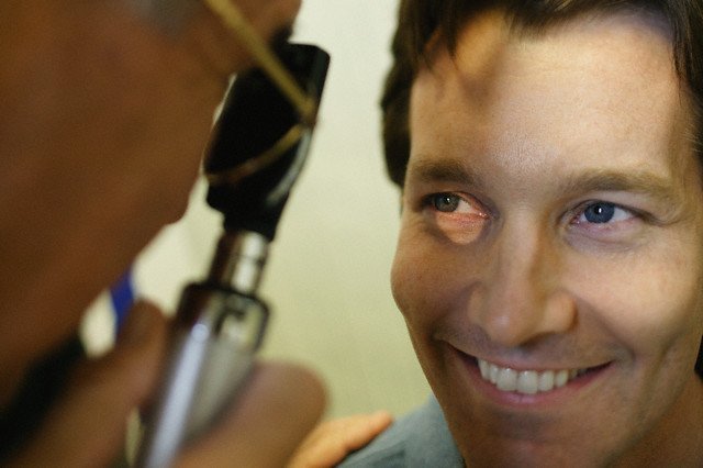 doctor examining man's eyes