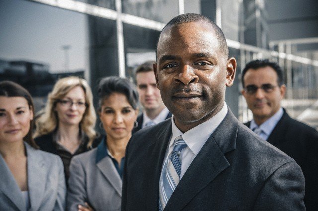 point man in business suit taking a photo with his tema