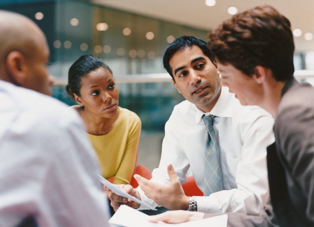 man in white shirt and tie who leads beyotnd his position talking to his followers
