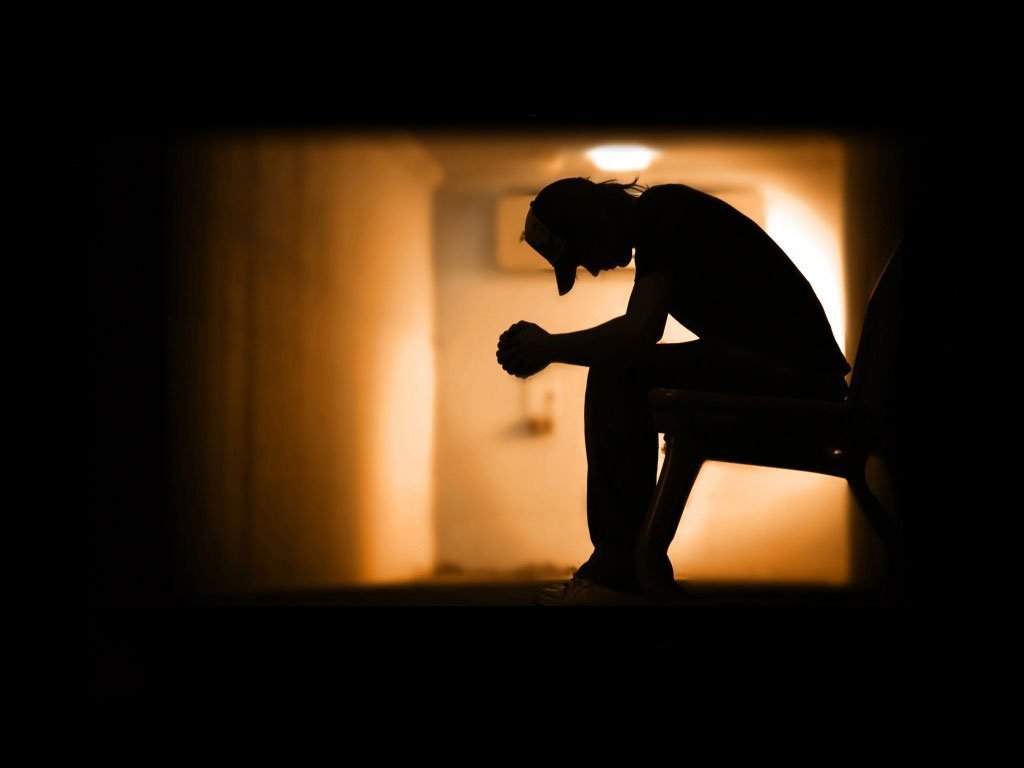 silhouette of man sitting in silence