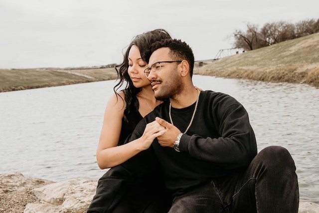 couple enjoying intimacy beside lake