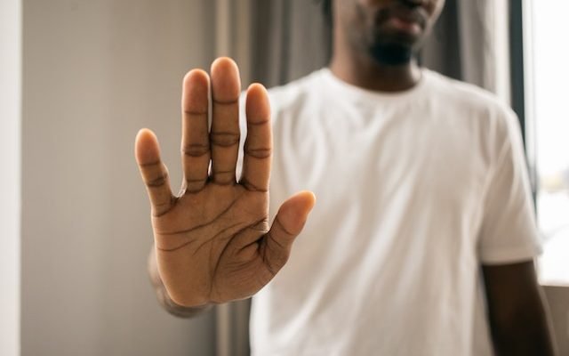 man raising his hand to say no