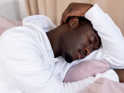 stressed man in white resting his head