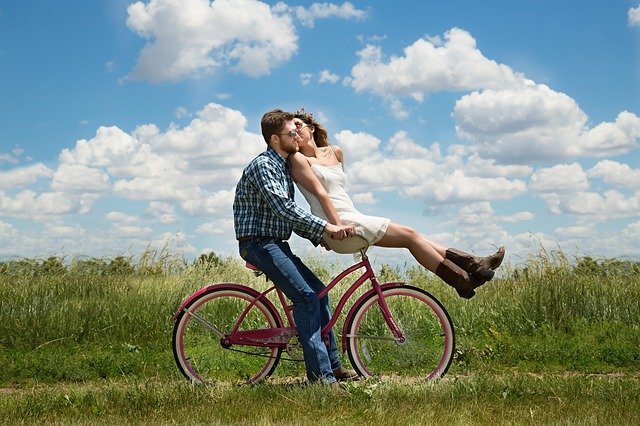 man who knows spouse love language bearing her on the handlebar of his bicycle