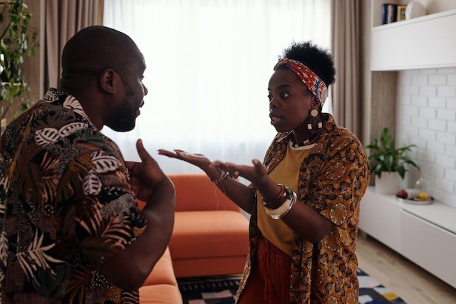 couple having an argument about bills in their sitting room