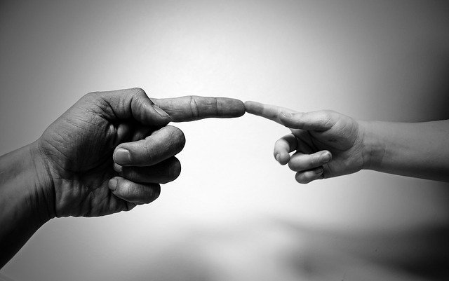 adult aligning a finger with a child as they motivate child
