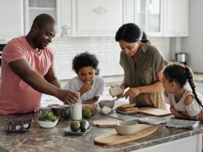 father preparing a meal with his family in the kitchen