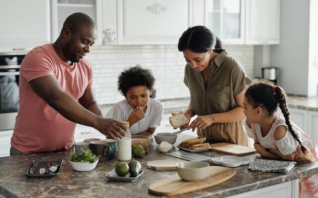 father preparing a meal with his family in the kitchen