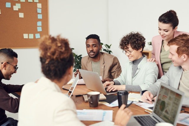 people engaging in workplace communication around a table