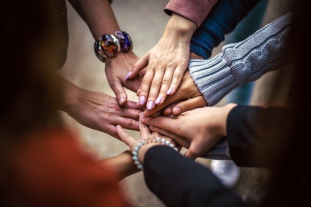 people of different skin colours joining nands together to show that they have saved their relationship