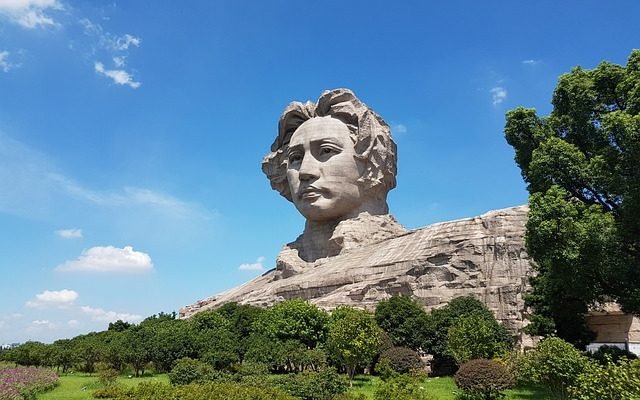 decision making - giant stone sculpture of giant beside green field