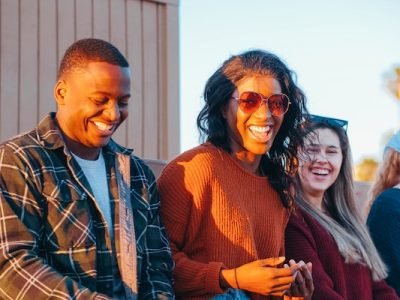group of people sitting in sunset and having fun