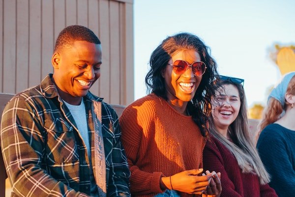 group of people sitting in sunset and having fun