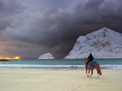 man in leadership position horseriding on beach with dark skies