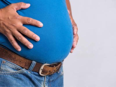 man with potbelly holding his stomach