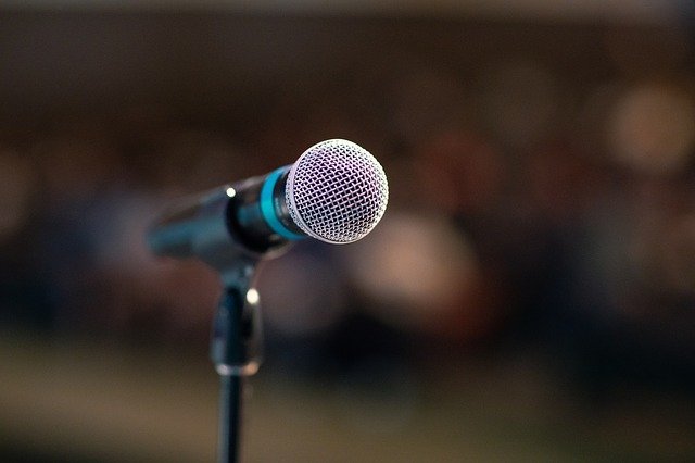 public speaking microphone facing speaker inside dark hall