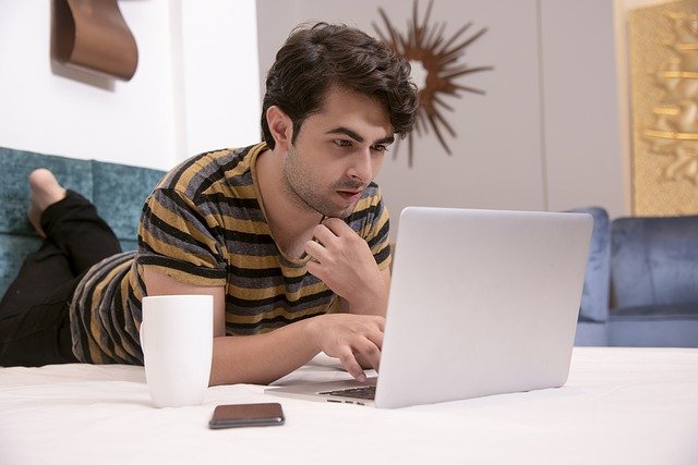 man on laptop working to earn credibility