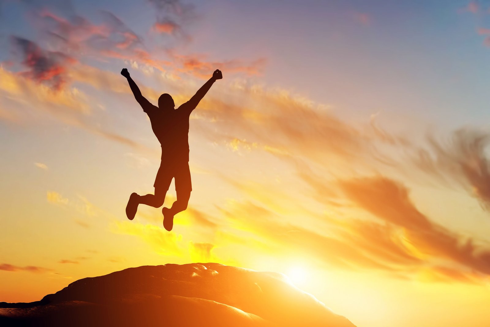 man jumping up in positivity at sunset