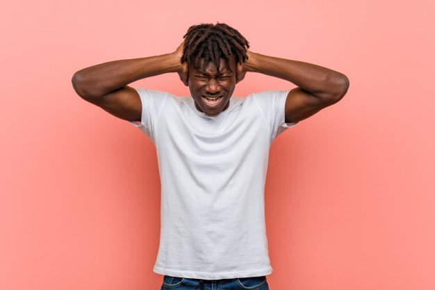 man with impostor syndrome holding his head