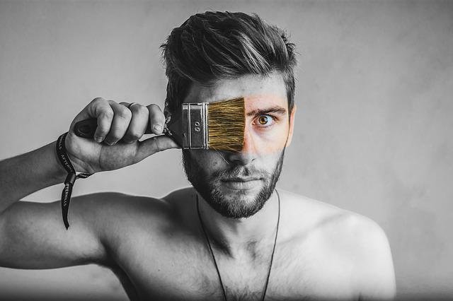 highly sensitive man running paint over his eyes with paintbrush
