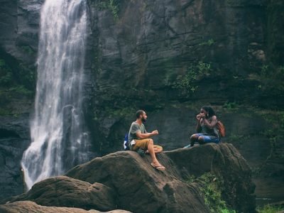 man and woman near waterfall in india practising good social habits