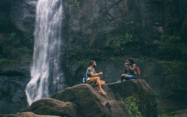 man and woman near waterfall in india practising good social habits