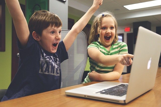 boy raising his arms in success beside his sister