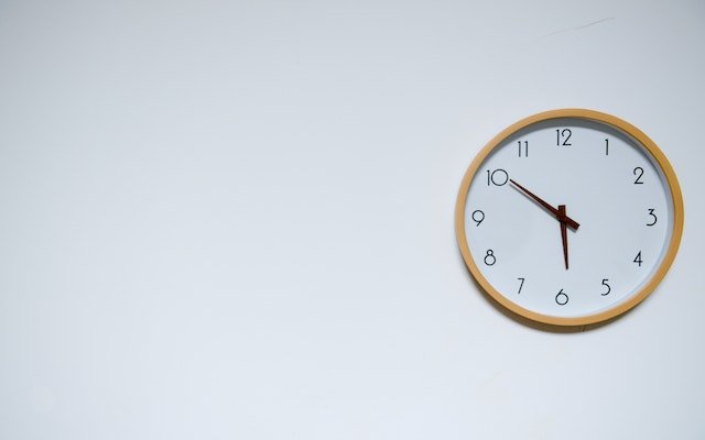white wall clock showing time on white wall