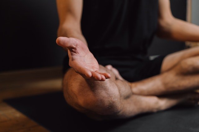Man living for something worthwhile practicing meditation on sports mat